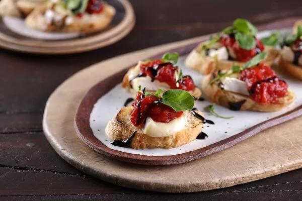 Brie Crostini Topped with Tomato Jam and Balsamic Syrup