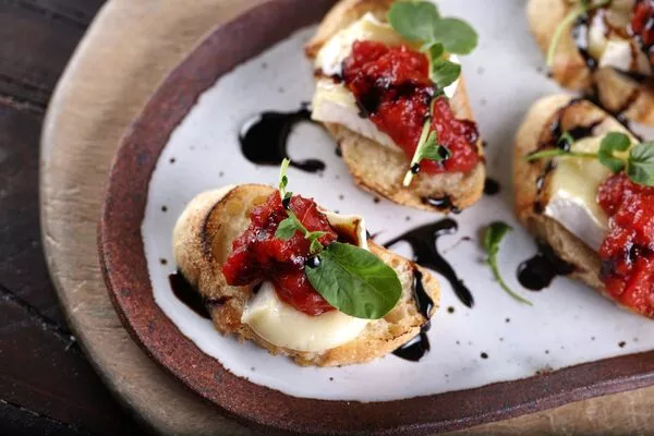 Brie Crostini Topped with Tomato Jam and Balsamic Syrup