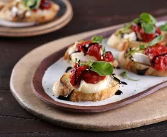 Brie Crostini Topped with Tomato Jam and Balsamic Syrup